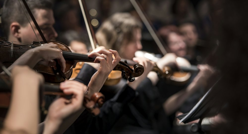 Violinistas de una orquesta, música clásica para estudiar