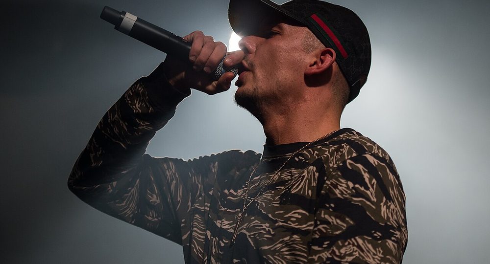 Rapero con gorra cantando en el micrófono