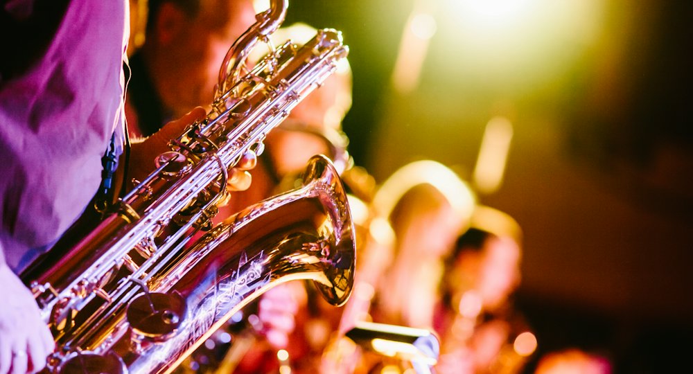 Saxofonista tocando jazz con luces cálidas